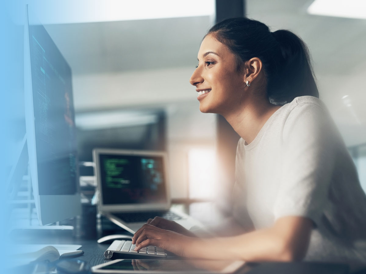Caucaisan female working in IT sitting at a laptop